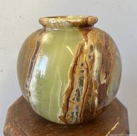 Front view showing multicolor natural marble pattern and bulbous round shape of the vase