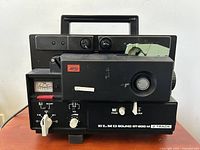 Front and top side view of Elmo Sound St. 600 M 2 Track projector showing control knobs, power meter, and carrying handle