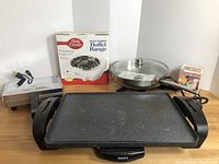 Full view of all items including the large electric griddle skillet, Betty Crocker buffet range box, Delfina electric skillet with lid, and box of pizzelle mix.