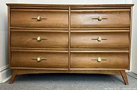 Front view of wooden dresser showing six drawers and brass-tone handles
