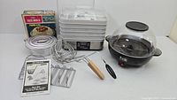 Wide view of entire lot showing Levco rice mold box, taco maker set components, Hamilton Beach food dehydrator and Popflix popcorn maker all arranged side by side.