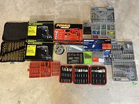 Full overview of all drills, drill bit cases, and accessory kits arranged on a floor.