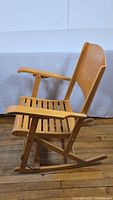 Side view of the maple wood folding rocking chair showing armrest, backrest, and rocking base