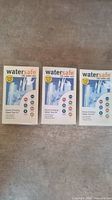 Three Watersafe city water test kit boxes placed side by side on a surface, showing front packaging