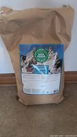Full view of 4 kg biodegradable paper bag of Gaia Green organic Diatomaceous Earth resting on floor.