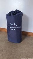 Image of the packed Fruiteam sleeping pad in a dark blue portable storage bag with the Fruiteam logo showing.