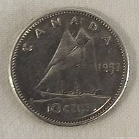 Reverse side of 1957 Canadian silver 10 cent coin showing Bluenose schooner and inscriptions.