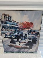 Front view of the framed 1973 Grand Prix of the United States poster showing the race cars and spectators.