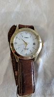 Vintage Timex wristwatch with brown leather strap and white dial showing date window