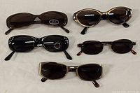 Top view showing all five pairs of sunglasses arranged on a surface