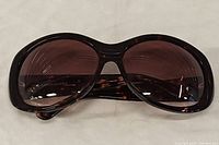 Photo of BCBG oversized sunglasses with brown tinted lenses and tortoiseshell frame, front view.