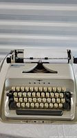 Full view of Cedarbrae beige manual typewriter with keys and paper loaded in roller