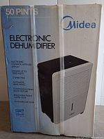 Front view of the factory sealed Midea dehumidifier box showing product features and image