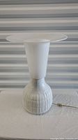 Front view of the white ceramic Rosenthal lamp showing textured lower portion and smooth tapered upper portion with wide top diffuser plate.