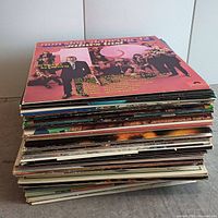 Stack of 31 vintage vinyl records showing spines and edges of album covers.
