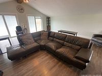 Room view of dark brown leather L-shaped sectional sofa with chaise lounge on left