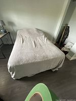 Double bed fully made with a white fitted sheet, situated in a room with a lamp on a side table.