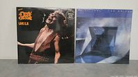 Front covers of two sealed vinyl records: Ozzy Osbourne Live EP and Billy Joel The Bridge album.