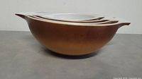 Single largest Pyrex mixing bowl showing brown exterior and white interior details.