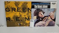Photo showing R.E.M. Green album cover next to John Mayall The Blues Alone album cover, highlighting cover artwork and condition