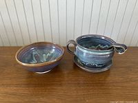 Front view of both stoneware bowls showing blue and brown glaze with interior patterns.