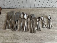 All flatware pieces arranged on stone surface