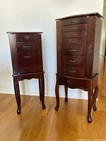 Both dark cherry wood jewelry armoires side by side