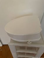 Side view of white raised toilet seat showing profile and locking mechanism.