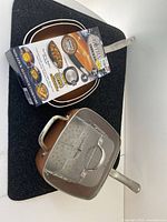 Two-piece Gotham Steel cookware set with fry pan, deep fry pot, mesh basket, and box showing product features.