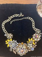 Close-up of Joan Rivers floral motif statement necklace with mixed colored crystals in bronze chunky chain