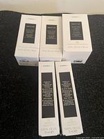 Five boxed Korres Black Pine skin care products arranged on a dark surface.