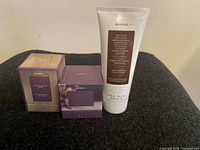 Photo showing two boxed Korres skin care products and one Korres cream tube on a black fabric surface.
