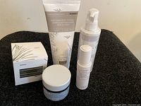 Five Korres branded skin care products arranged on black fabric showing the variety of containers and sizes.