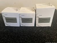 Three boxed Korres White Pine Volumizing Serum-in-Moisturizers with sizes 40 ml and 100 ml, showing front packaging.