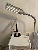 Full photo of the OttLite floor lamp showing adjustable flexible neck and fluorescent bulb housing with electric cord.