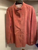 Front view of pink suede women's jacket, showing button-up front, stand collar, and long sleeves.