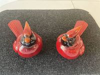 Top down view of two cardinal figurines showing details and size comparison