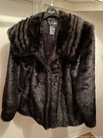 Front view of the large women's short faux fur mink coat by Regal featuring a dark brown color and striped collar design.