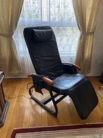 Full view of recliner in upright position by window, showing overall structure and condition