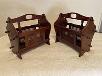 Two traditional wooden magazine racks side by side on fabric surface showing front and side views.