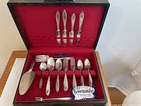Flatware set open in case showing 35 pieces of Wm. Rogers & Son silver plated flatware in Adam 1917 pattern with red velvet lining.