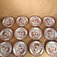 Top-down view of all 12 plates laid out in a grid showing floral and tree pattern design.