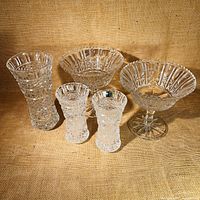 Full view of the 5-piece crystal set including 2 compote dishes, 1 tall vase, and 2 smaller vases on a fabric background.