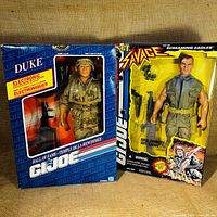 Front view of G.I. Joe Duke action figure in original box with electronic label and Sgt. Savage figure in yellow box with motorized accessories.