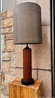 Full view of lamp showing wood finish base and cane-covered double layered shade.