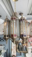 Front view of the Moroccan style brass chandelier showing multicolored glass panels and brass frame
