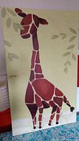 Full view of the giraffe artwork showing size, style, and condition including visible wear and patches of color forming the giraffe on a naturalistic background.