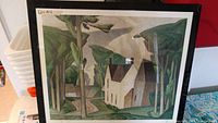 Framed limited edition print showing village house scene amid trees