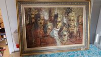 Full view of original oil painting showing group of faces with ornate gold frame, table and room edges visible