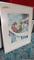Framed signed print showing abstract figures sitting by a balcony railing with a blue sky background.